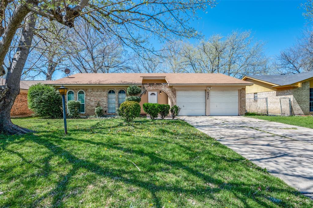 a view of a white house next to a yard with plants and trees