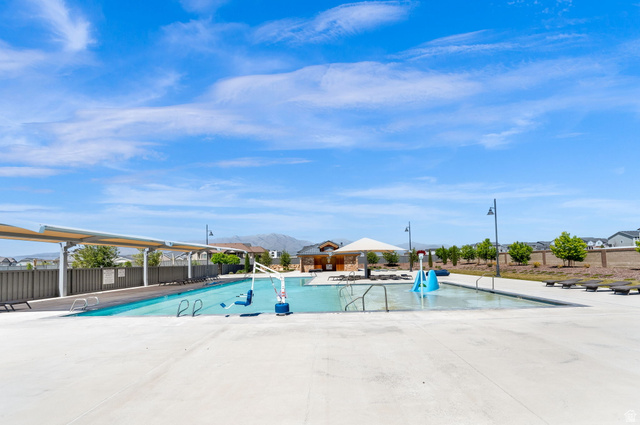 6120 North Sheps Ridge Road Eagle Mountain, UT 84005 - Photo 29 of 43 Community swimming pool featuring a shallow entry, integrated water play equipment, and shaded lounge areas