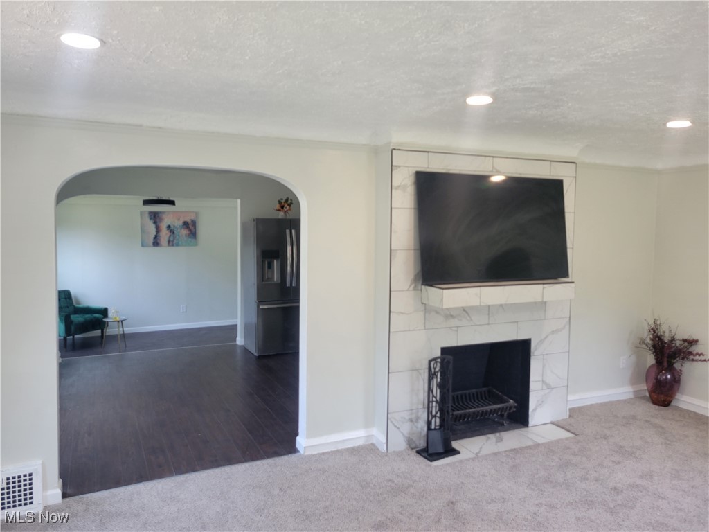 1557 Maplegrove Road South Euclid, OH 44121 - Photo 14 of 23 Unfurnished living room featuring a textured ceiling, a tile fireplace, and hardwood / wood-style flooring