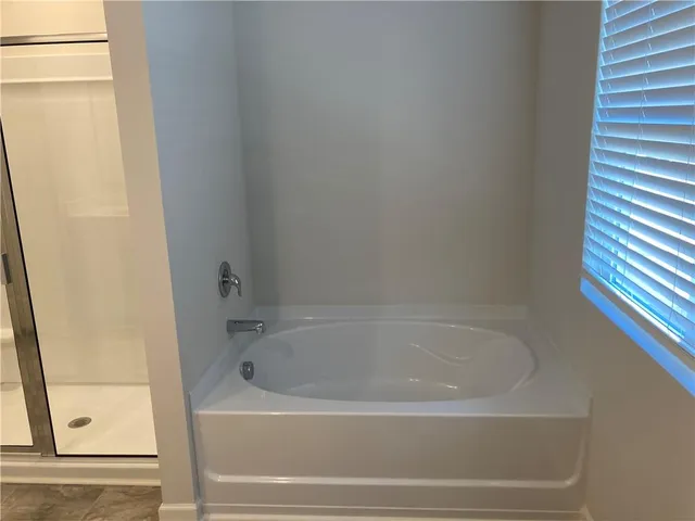 a white bath tub sitting next to a shower
