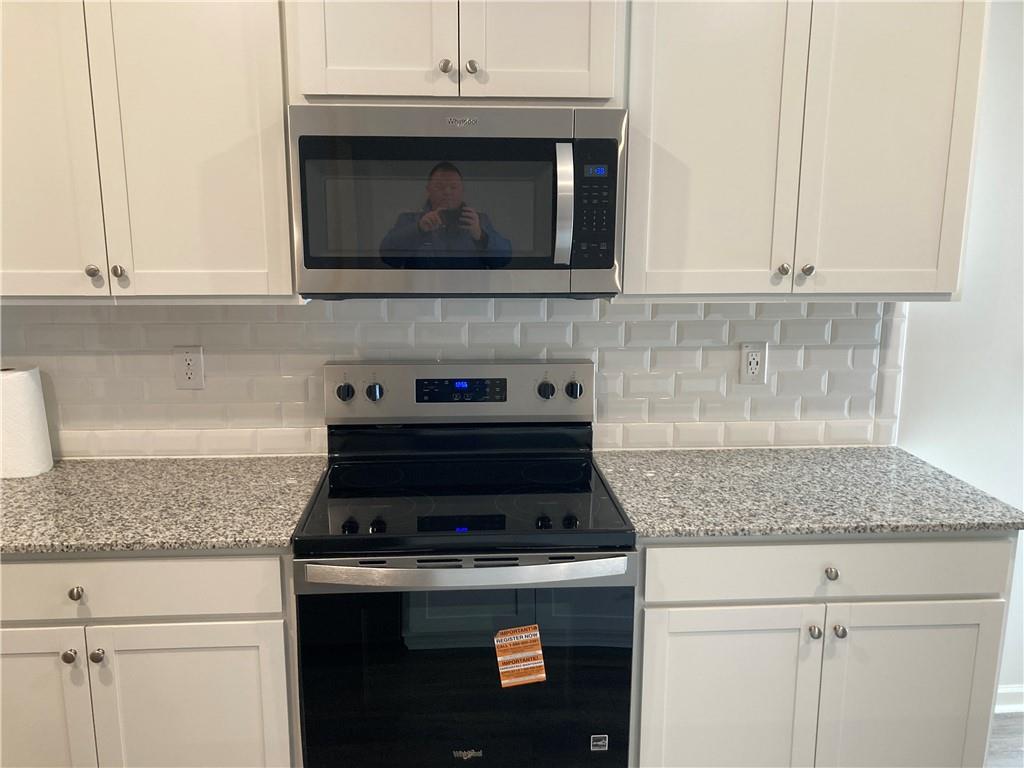 28 Rustin Ridge Dahlonega, GA 30533 - Photo 5 of 23 a kitchen with granite countertop white cabinets and stainless steel appliances
