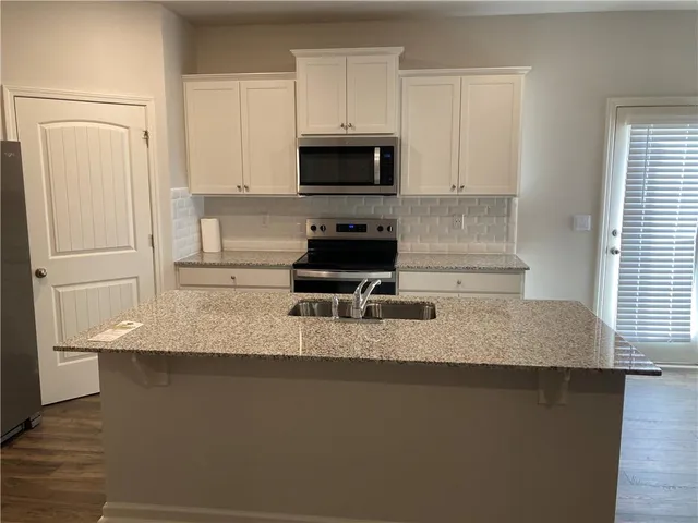 a kitchen with sink a microwave and refrigerator