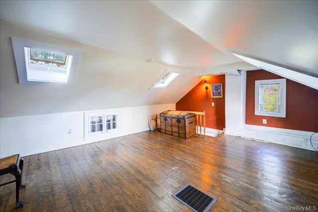 a room with wooden floor and a view of kitchen