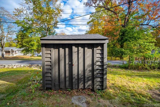 a view of a backyard with wooden fence and large trees