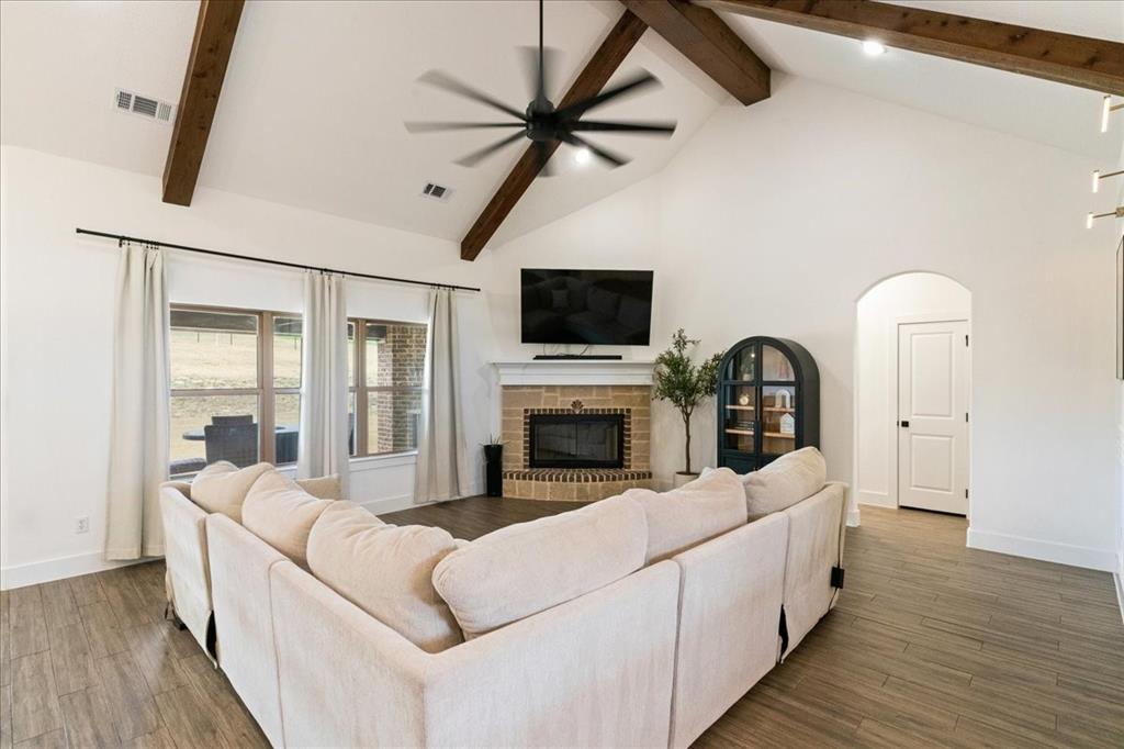 3021 Westfork Way Springtown, TX 76082 - Photo 11 of 35 a living room with furniture a fireplace and a flat screen tv