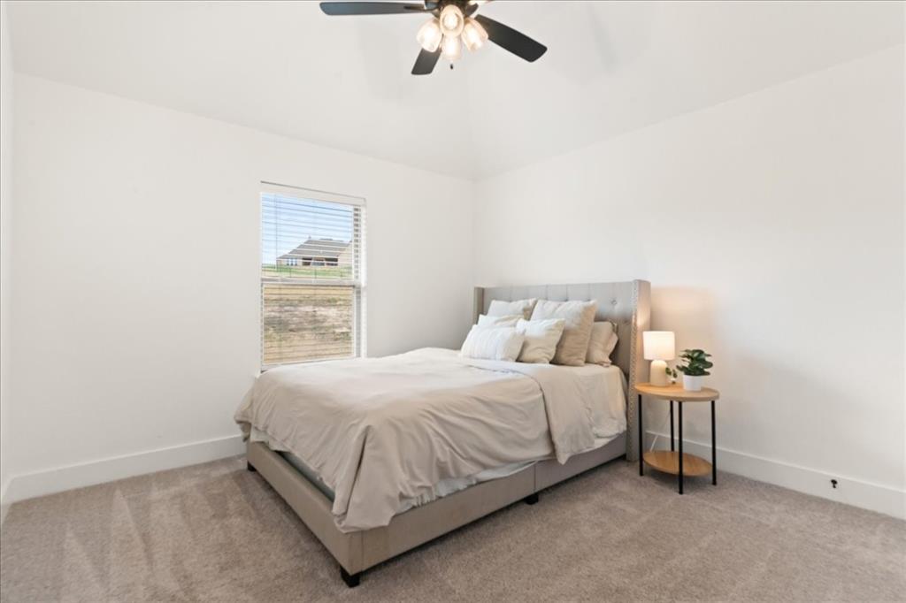 3021 Westfork Way Springtown, TX 76082 - Photo 17 of 35 a bedroom with a bed and a chandelier fan
