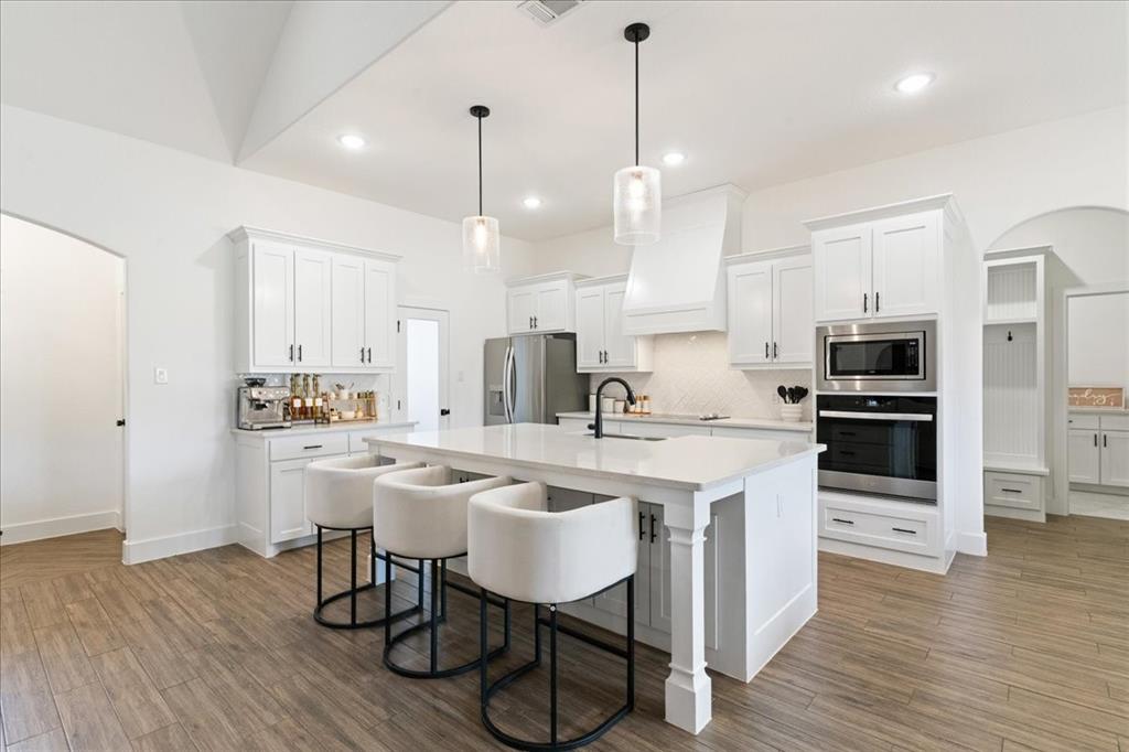 3021 Westfork Way Springtown, TX 76082 - Photo 5 of 35 a kitchen with stainless steel appliances granite countertop a sink a stove a refrigerator and island with wooden floor