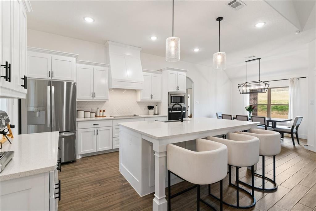 3021 Westfork Way Springtown, TX 76082 - Photo 6 of 35 a kitchen with refrigerator a sink and chairs