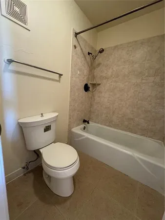 a white toilet sitting next to a bath tub and a shower