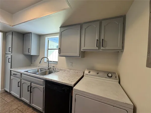 a utility room with sink dryer and washer