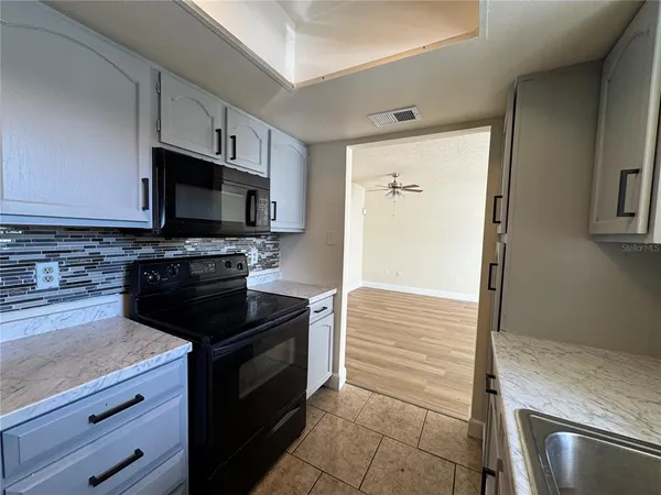 a kitchen with granite countertop a stove and a microwave