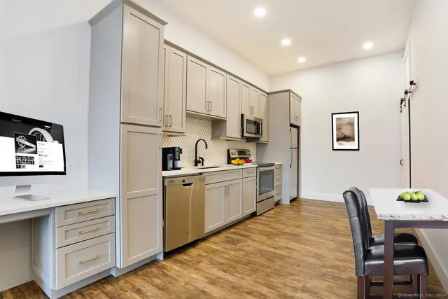 a kitchen with cabinets and wooden floor