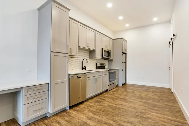 a kitchen with white cabinets and white appliances