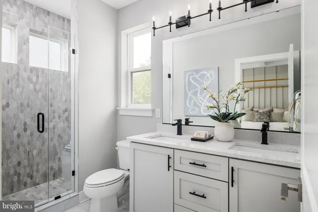 a bathroom with a granite countertop sink a toilet and shower