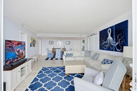 a living room with furniture a large window and a flat screen tv