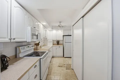 a kitchen with cabinets appliances a sink and a window
