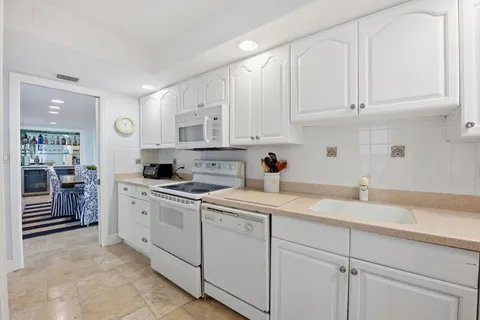 a large white kitchen with cabinets and stainless steel appliances