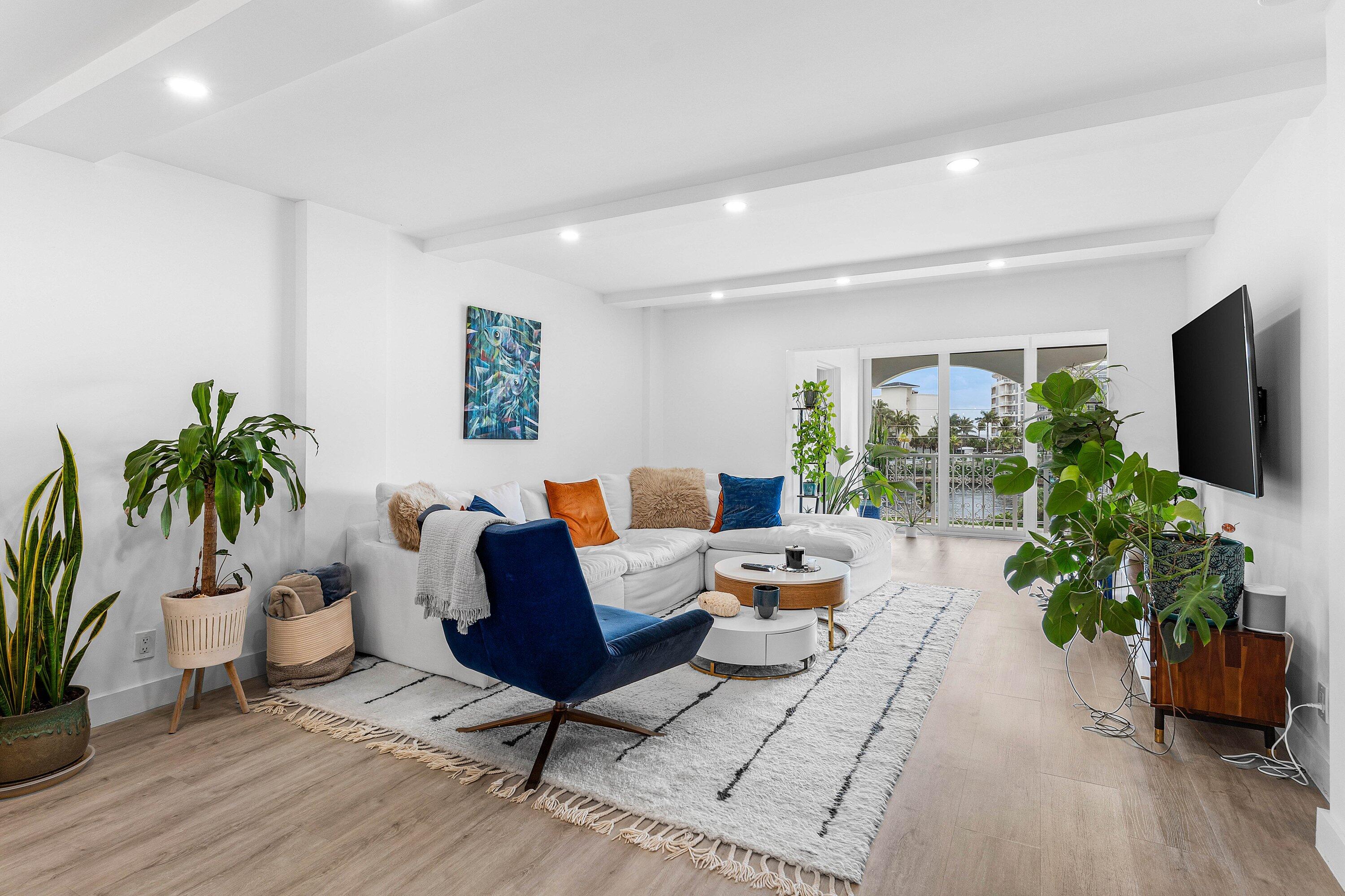1001 East Camino Real, Unit 4040 Boca Raton, FL 33432 - Photo 12 of 44 a living room with furniture potted plant and a flat screen tv