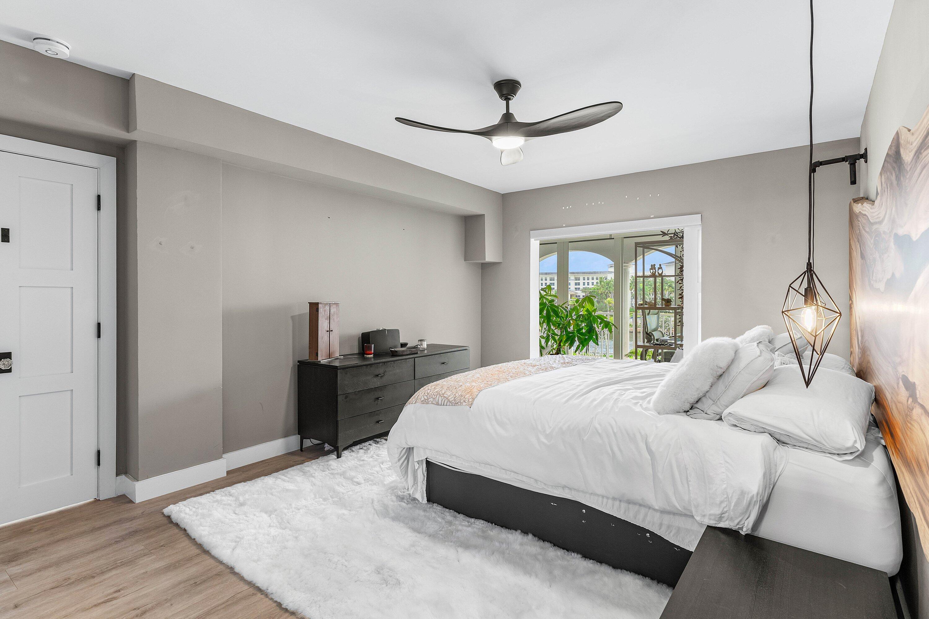 1001 East Camino Real, Unit 4040 Boca Raton, FL 33432 - Photo 19 of 44 a bedroom with a bed and wooden floor