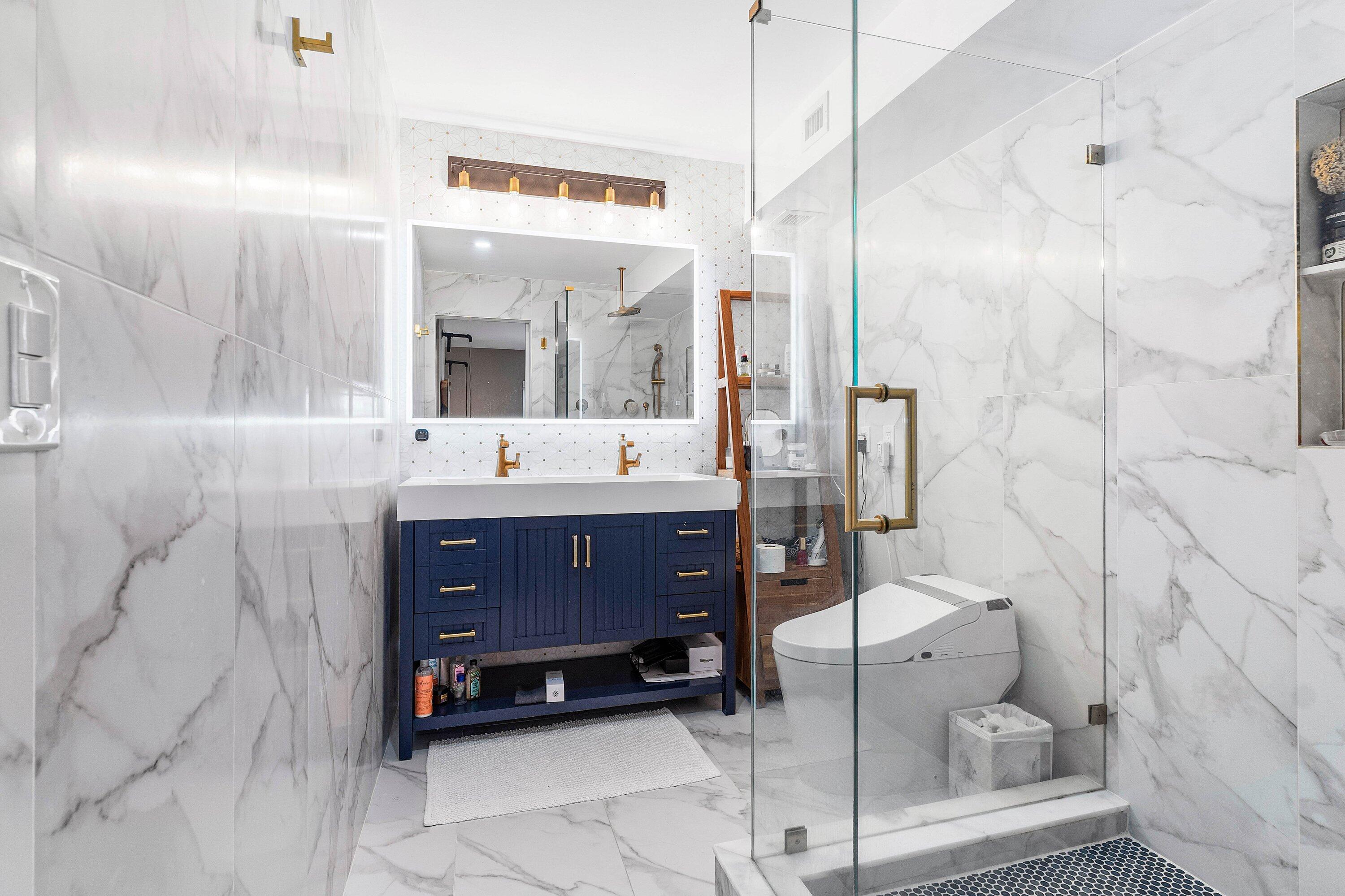 1001 East Camino Real, Unit 4040 Boca Raton, FL 33432 - Photo 22 of 44 a bathroom with a sink a toilet and mirror