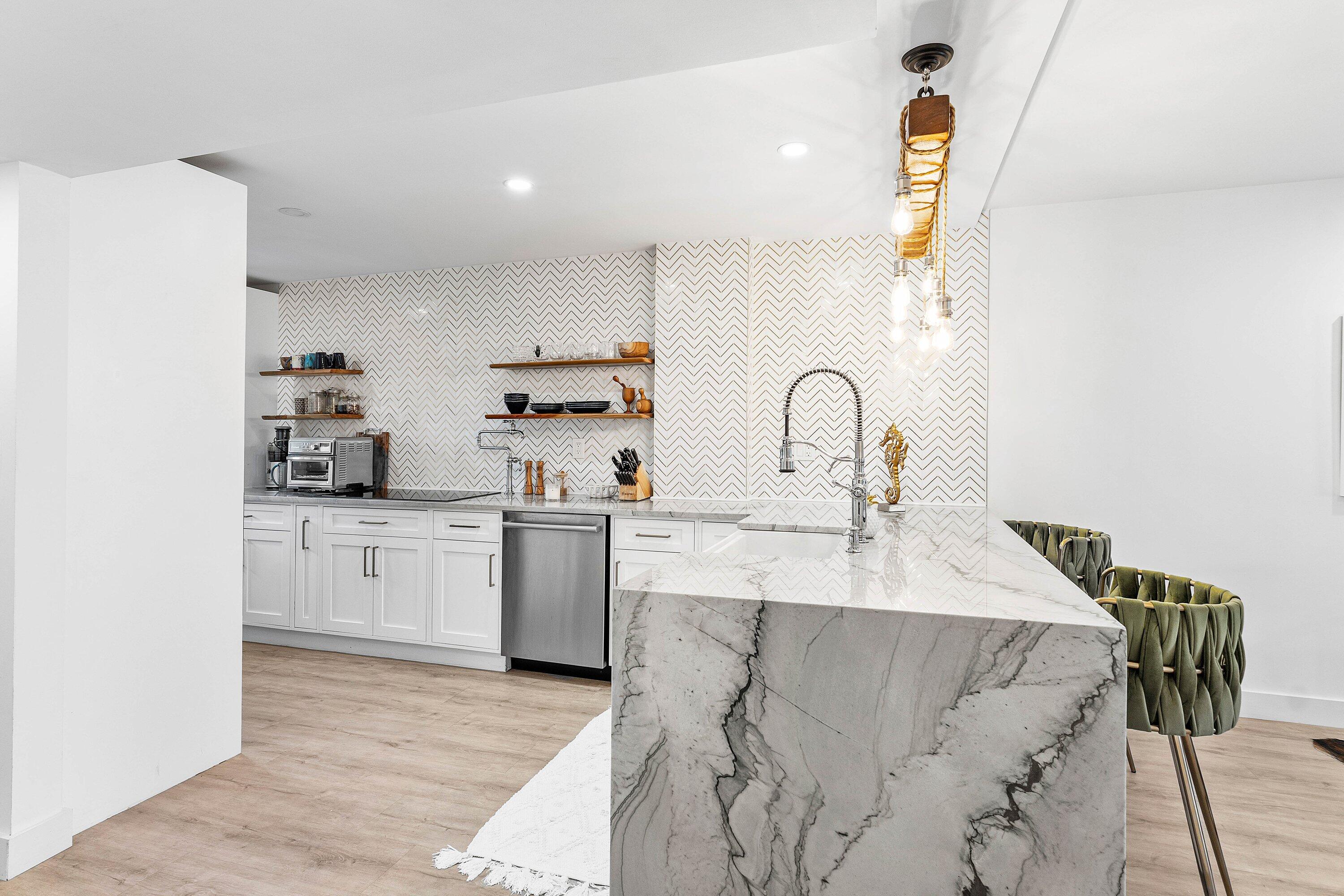 1001 East Camino Real, Unit 4040 Boca Raton, FL 33432 - Photo 5 of 44 a kitchen with a sink white cabinets and appliances