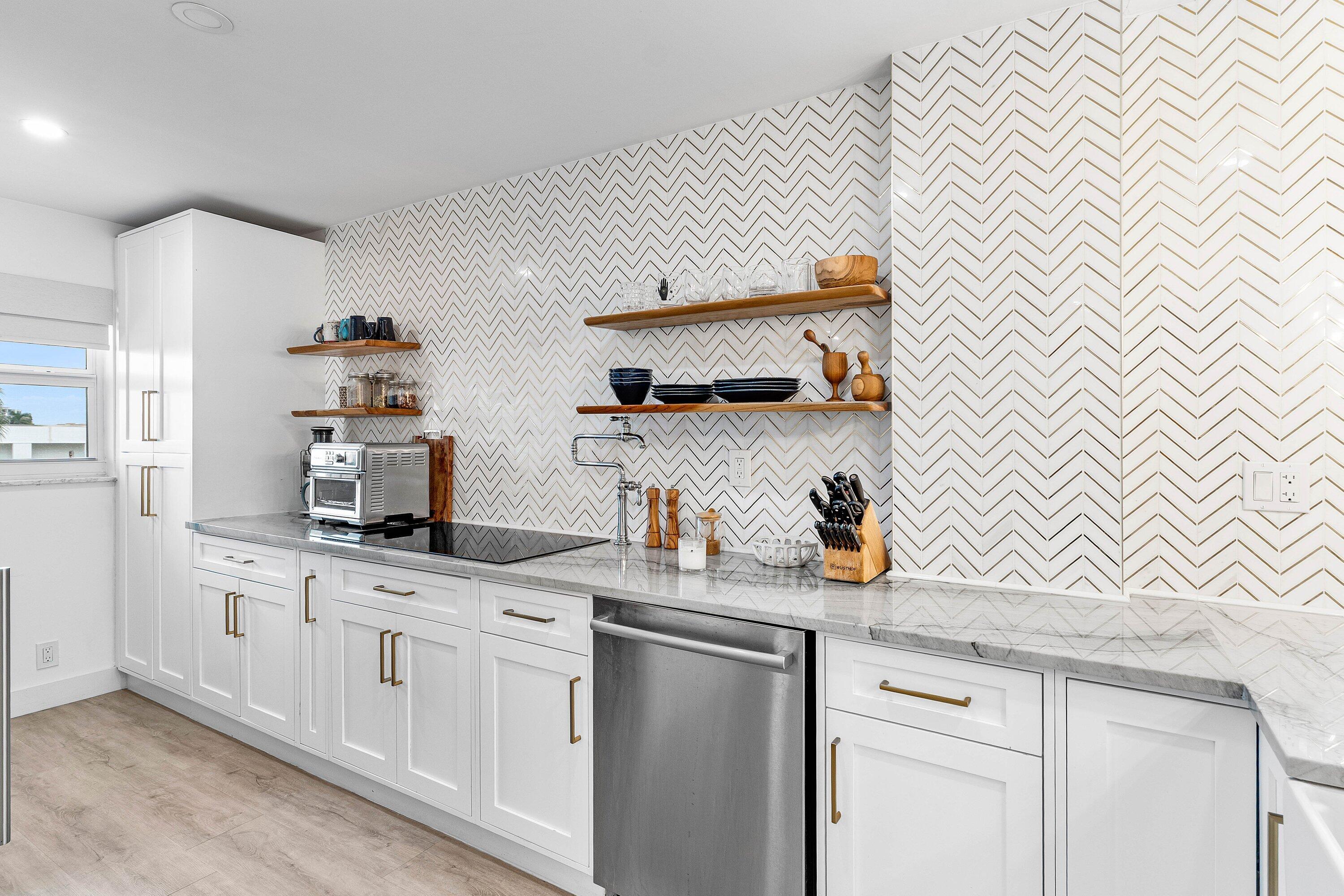 1001 East Camino Real, Unit 4040 Boca Raton, FL 33432 - Photo 6 of 44 a kitchen with white cabinets and appliances