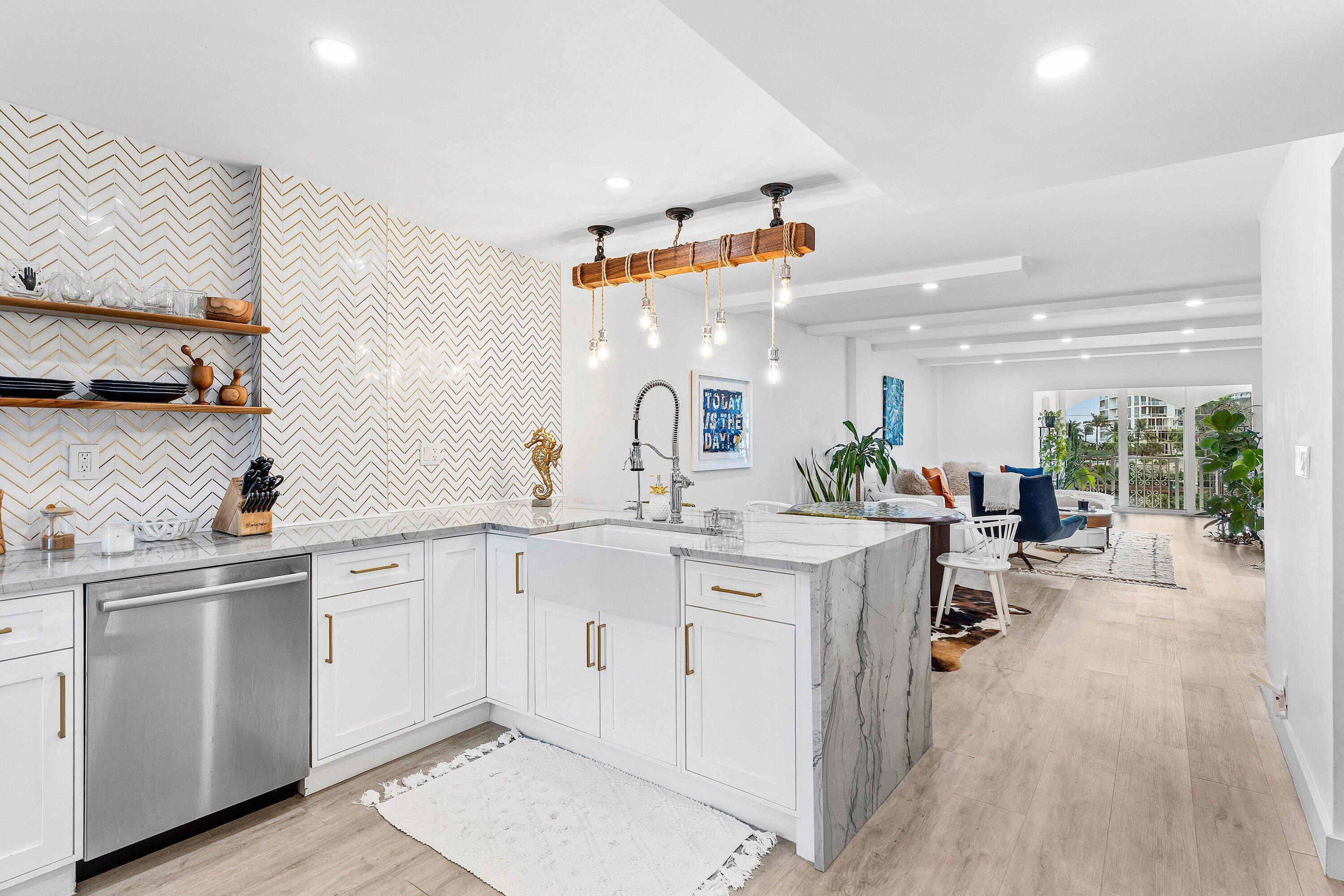 1001 East Camino Real, Unit 4040 Boca Raton, FL 33432 - Photo 7 of 44 a kitchen with white cabinets and sink