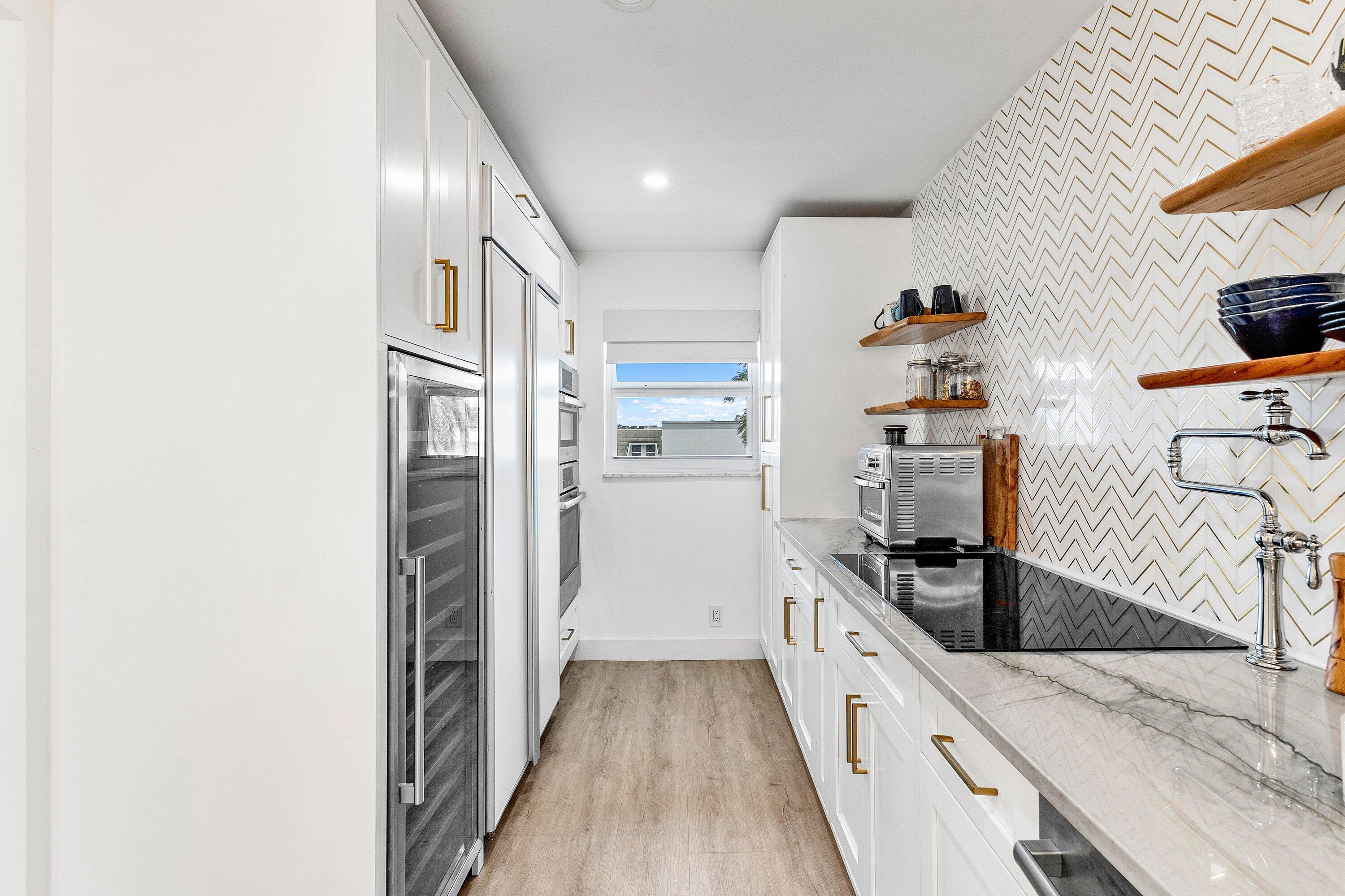1001 East Camino Real, Unit 4040 Boca Raton, FL 33432 - Photo 8 of 44 a kitchen with granite countertop a refrigerator and a sink