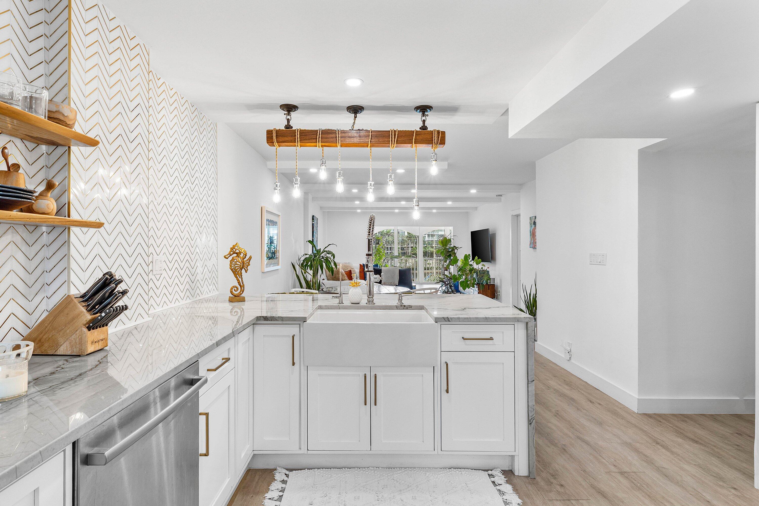 1001 East Camino Real, Unit 4040 Boca Raton, FL 33432 - Photo 10 of 44 a kitchen with white cabinets and sink