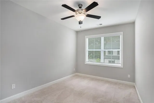 an empty room with a window and a ceiling fan