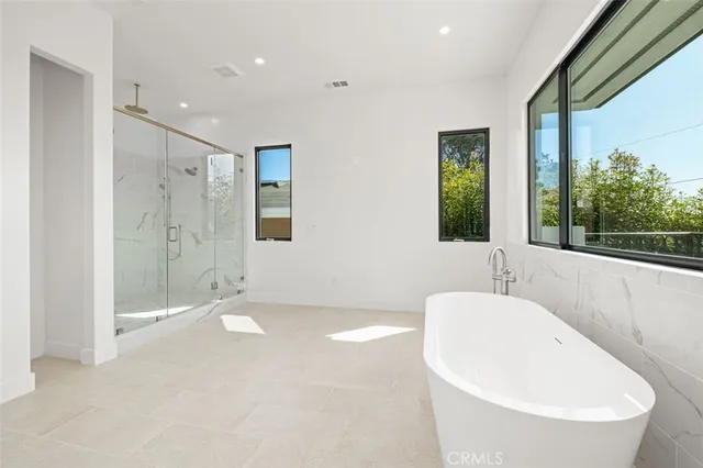 a spacious bathroom with a tub shower and sink
