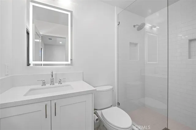 a bathroom with a sink toilet vanity and shower