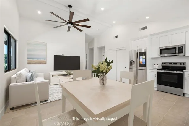 a kitchen with stainless steel appliances kitchen island granite countertop a sink and a refrigerator