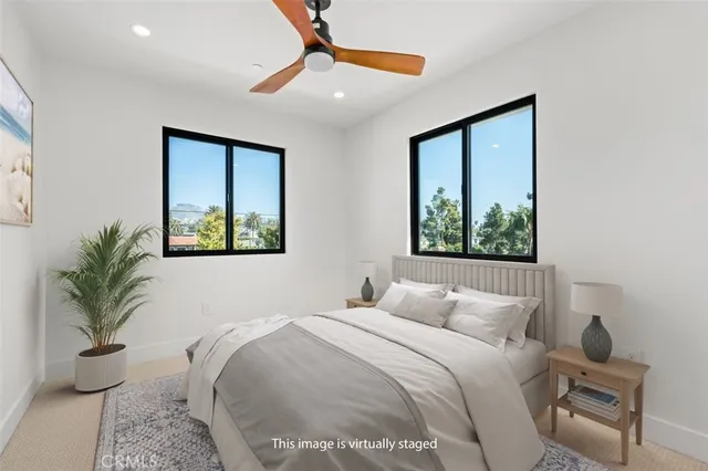 a bedroom with a large bed and a potted plant