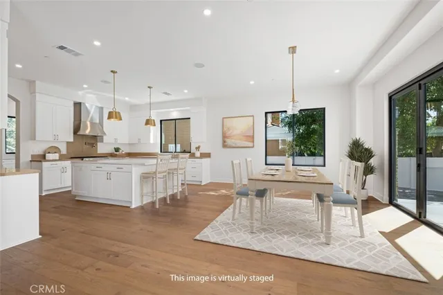 a large kitchen with kitchen island a large counter top space a sink stainless steel appliances and cabinets