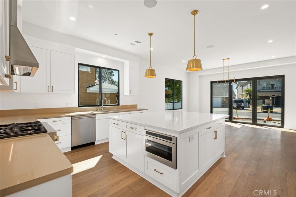 34882 Doheny Place Dana Point, CA 92624 - Photo 6 of 42 a kitchen that has a stove a sink and a wooden floor