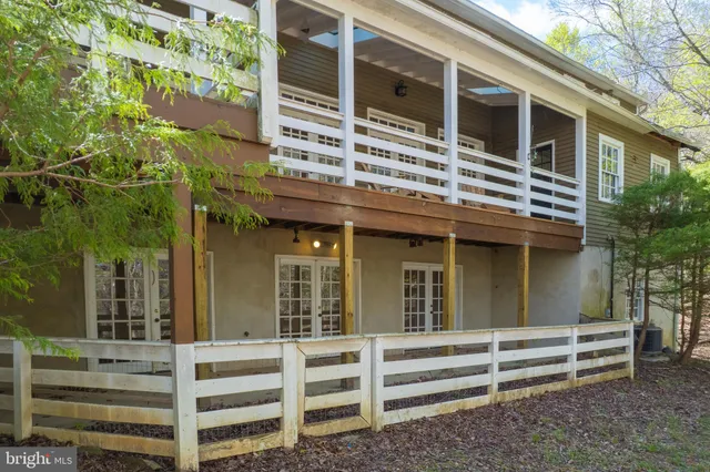 a view of an empty room with wooden floor and stairs