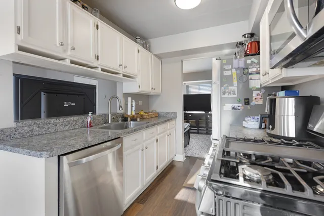 a kitchen with stainless steel appliances granite countertop a stove sink and cabinets