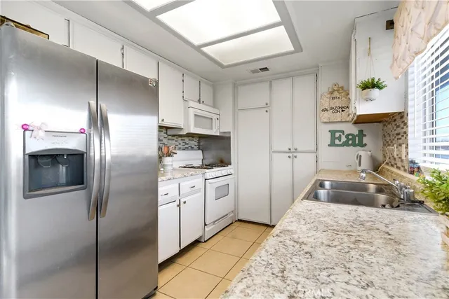 a kitchen with granite countertop a refrigerator and a sink