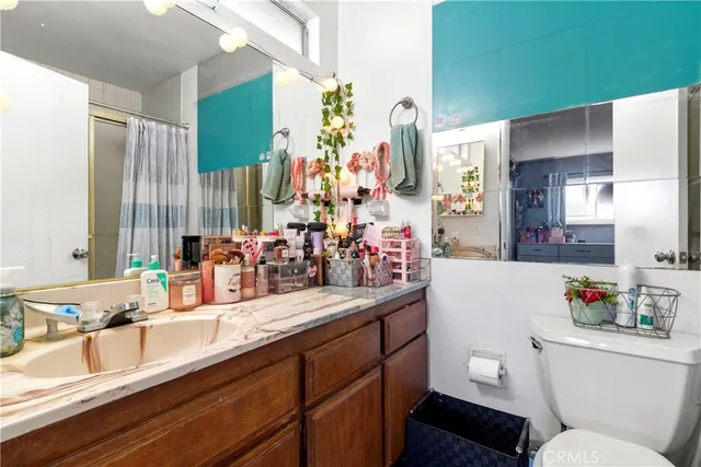 a bathroom with a double vanity sink toilet and a tub
