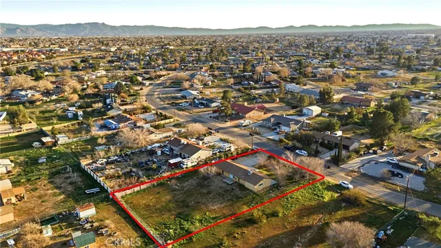 an aerial view of residential houses with outdoor space and trees