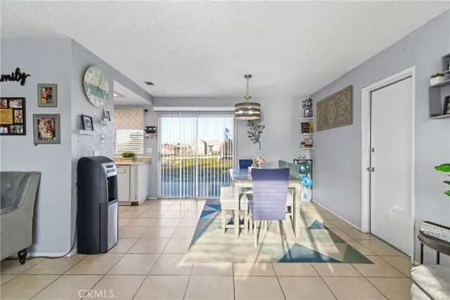 a living room with furniture a dining table and a refrigerator