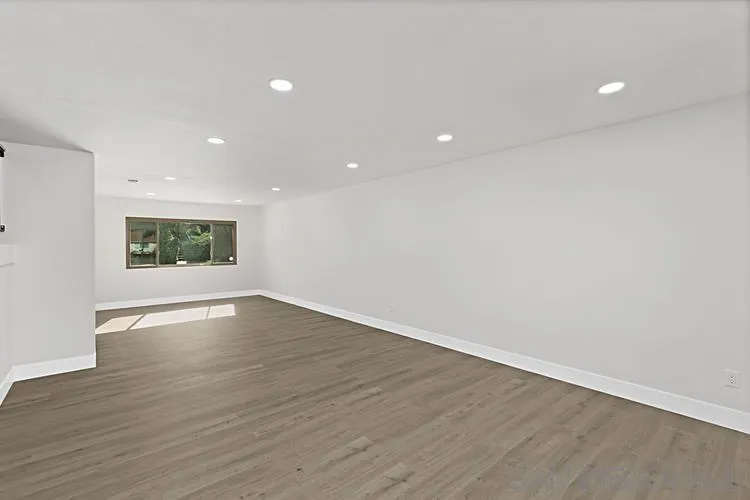 4334 Corral Canyon Road Bonita, CA 91902 - Photo 12 of 32 a view of an empty room with wooden floor and a window