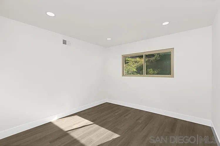 4334 Corral Canyon Road Bonita, CA 91902 - Photo 19 of 32 an empty room with wooden floor and windows