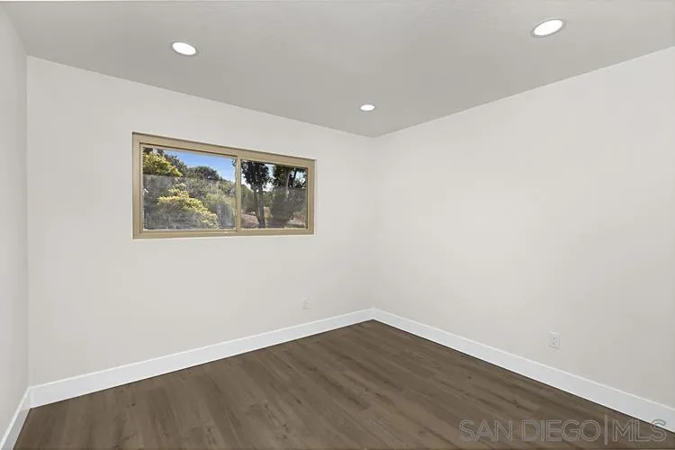 4334 Corral Canyon Road Bonita, CA 91902 - Photo 20 of 32 an empty room with wooden floor and window