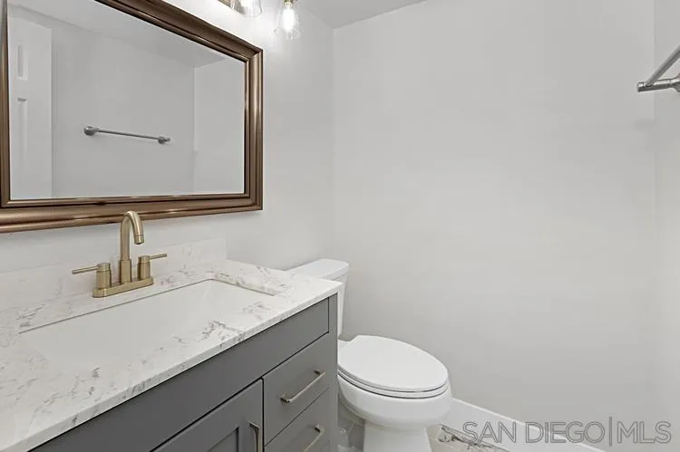 4334 Corral Canyon Road Bonita, CA 91902 - Photo 4 of 32 a bathroom with a granite countertop toilet sink and mirror