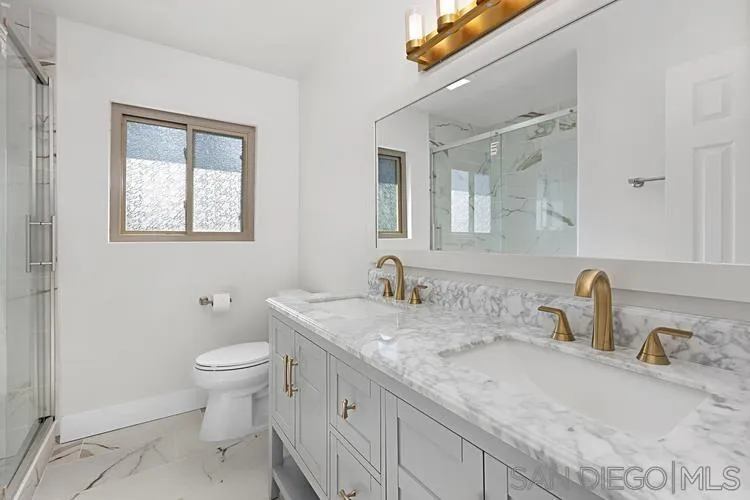 4334 Corral Canyon Road Bonita, CA 91902 - Photo 6 of 32 a bathroom with a granite countertop sink a toilet and a mirror