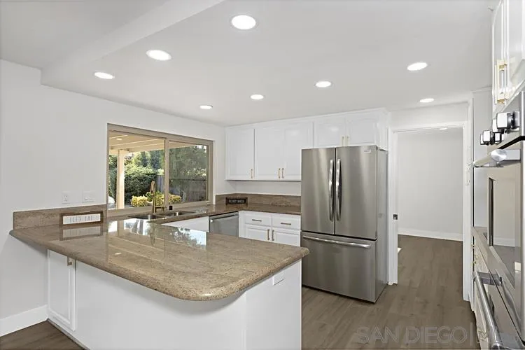 4334 Corral Canyon Road Bonita, CA 91902 - Photo 7 of 32 a kitchen with granite countertop a refrigerator a sink a stove a dining table and chairs