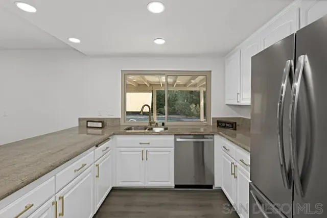 a kitchen with granite countertop a stove a microwave and cabinets