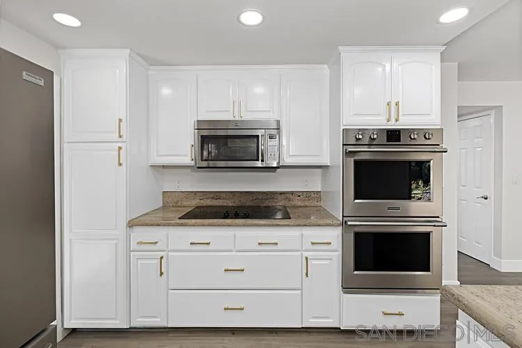 4334 Corral Canyon Road Bonita, CA 91902 - Photo 9 of 32 a kitchen with granite countertop a stove a microwave and cabinets